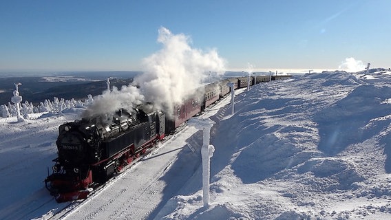 Die Brockenbahn fährt durch eine verschneite Landschaft. © NDR Foto: Matthias Strauß
