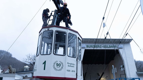 A cabin of the Burgberg cable car is removed from the suspension cable.  © Swen Pförtner/dpa Photo: Swen Pförtner