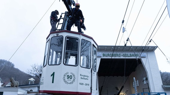 A cabin of the Burgberg cable car is removed from the suspension cable.  © Swen Pförtner/dpa Photo: Swen Pförtner