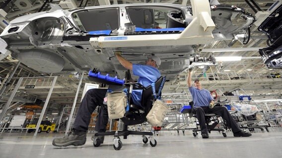 Mitarbeiter des Volkswagenwerkes arbeiten an einem VW Passat. © dpa-Bildfunk Foto:  Erik S. Lesser