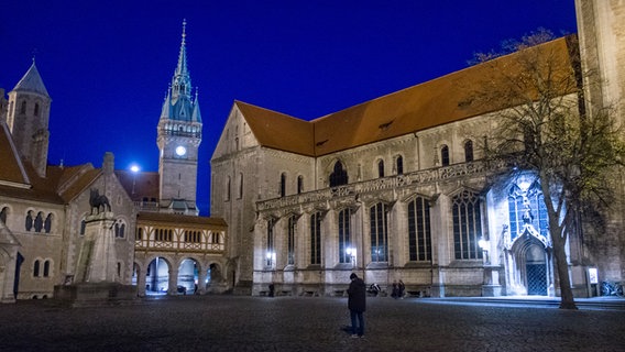 Der Burgplatz mit der Burg Dankwarderode (l-r), dem Rathaus und dem Braunschweiger Dom am frühen Abend. Nur wenige Menschen auf dem Platz. © dpa-Bildfunk Foto: Stefan Jaitner
