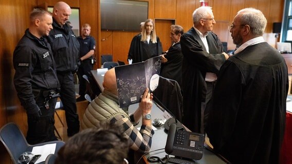 Zwei von vier Angeklagten in einem Betrugsprozess sitzen im Landgericht Göttingen auf der Anklagebank. © dpa Foto: Swen Pförtner
