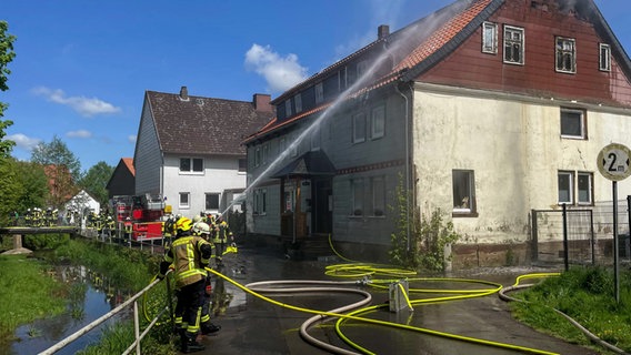 Feuerwehrleute löschen einen Brand in einem Haus. © Kreisfeuerwehr Northeim Foto: Fabian Hesse