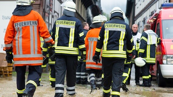 Einsatzkräfte der Feuerwehr gehen in Goslar durch die historische Altstadt. © picture alliance/dpa Foto: Swen Pförtner
