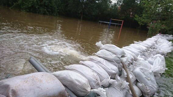 Wasser wird über einen Wasserschutzdamm aus Sandsäcken in die Oker gepumpt. © NDR Foto: Tino Nowitzki