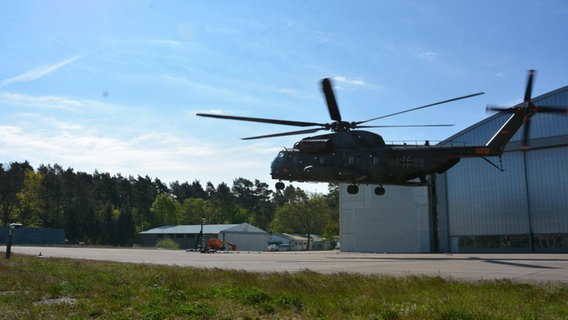 Ein Hubschrauber im Schwebeflug vor einem Hanger. © DLR (CC BY-NC-ND 3.0) 