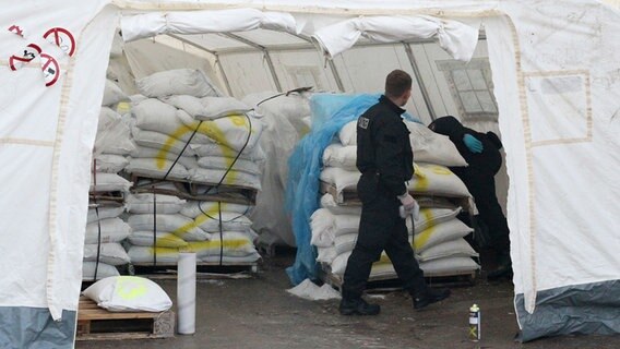 Polizisten inspizieren Säcke in einem Zelt. © dpa-bildfunk Foto: Silvio Dietzel