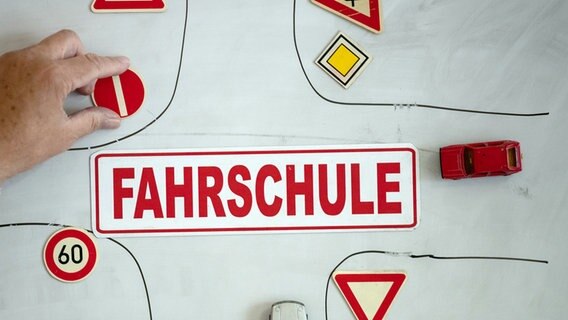Ein Magnet mit der Aufschrift «Fahrschule» ist an einer Wandtafel mit verschiedenen Verkehrsymbolen zu sehen. © dpa-Bildfunk Foto: Swen Pförtner