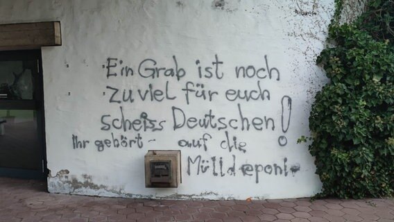 An einer Wand auf einem Friedhof ist die Schmiererei "Ein Grab ist noch zuviel für euch scheiss Deutschen! Ihr gehört auf die Mülldeponie" zu sehen. © HannoverReporter 