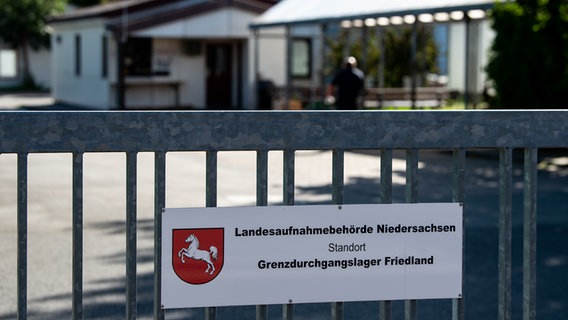 An einem Tor am Grenzdurchgangslager Friedland weist ein Schild auf den Standort der Landesaufnahmebehörde Niedersachsen hin. © picture alliance/dpa/Swen Pförtner Foto: Swen Pförtner