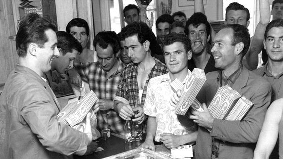 Eine Gruppe italienischer Gastarbeiter 1962 in Wolfsburg beim Kauf von Spaghetti. © picture alliance Foto: Hans Heckmann