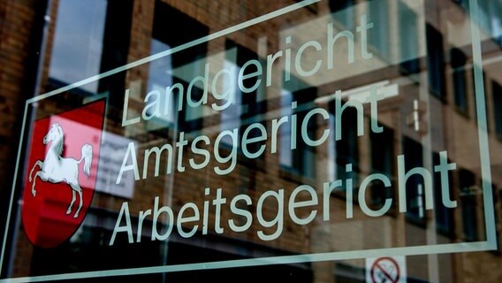 Der Schriftzug «Landgericht, Amtsgericht, Arbeitsgericht» ist am Haupteingang im Landgericht in Göttingen (Niedersachsen) mit einer Spiegelung des Gerichtsgebäudes zu sehen. © picture alliance/dpa/Swen Pförtner Foto: Swen Pförtner