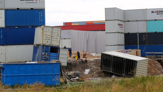 Teilweise umgestürzte Container liegen rund um die Sprengkrater auf dem Schützenplatz Göttigen. © Stefan Rampfel/dpa Foto: Stefan Rampfel