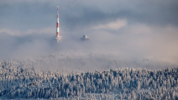 Blick vom Skigebiet am Sonnenberg auf den Brocken mit seiner Funkmastanlage. Die Bäume sind mit Schnee bedeckt und die Funkmastanlage in Nebel gehüllt. © picture alliance/dpa | Swen Pförtner Foto: Swen Pförtner