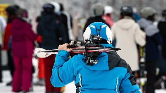 Eine Skifahrerin trägt ihrer Skier am Wurmberg im Harz. © picture alliance/dpa Foto: Swen Pförtner