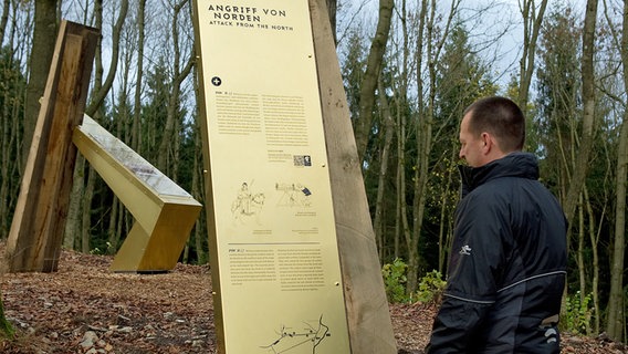 Ein Mann liest an einer Informationstafel am Harzhorn. © dpa-Bildfunk Foto: Swen Pförtner