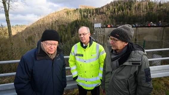 Altenau: (v.l.n.r.) Stephan Weil (SPD), Dieter Rohrberg, Landesbranddirektor Niedersachsen, und Andreas Lange, Harzwasserwerke, stehen vor der Okertalsperre im Harz. © dpa Foto: Julian Stratenschulte