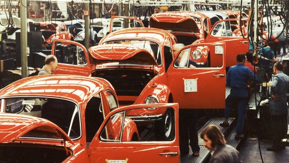 Rote VW Käfer stehen aufgereiht in einer Fabrik. © Volkswagen AG 