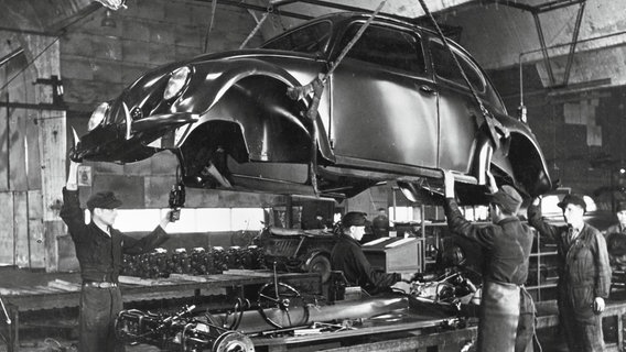 Ein VW Käfer hängt in einer Werkstatt von der Decke. © Volkswagen AG 