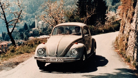 Ein VW Käfer fährt über eine Landstraße. © Volkswagen AG 
