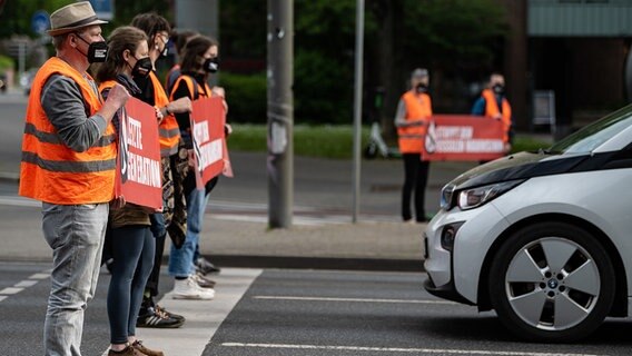 Klimaaktivisten demonstrieren auf einer Straße in Göttingen. Klimaaktivisten demonstrieren auf einer Straße in Göttingen. © Swen Pförtner/dpa Foto: Swen Pförtner