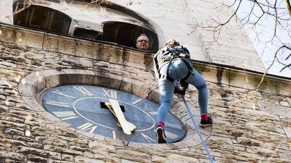 Konfirmandin Finja klettert einen Kirchturm der Jugendkirche in Braunschweig herab. © Michael Matthey/dpa Foto: Michael Matthey