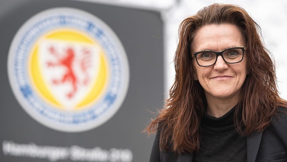 Nicole Kumpis steht vor dem Logo von Eintracht Braunschweig. © picture alliance/dpa | Swen Pförtner Foto: Swen Pförtner