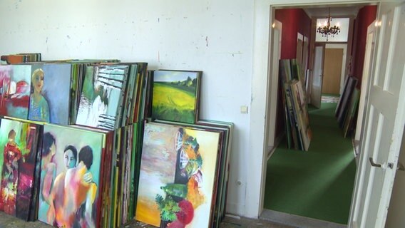 Zahlreiche Gemälde stehen in einer Wohnung. © NDR 