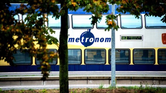 Ein Zug der Metronom Eisenbahngesellschaft steht auf einem Gleis im Bahnhof. © picture alliance/dpa Foto: Hauke-Christian Dittrich