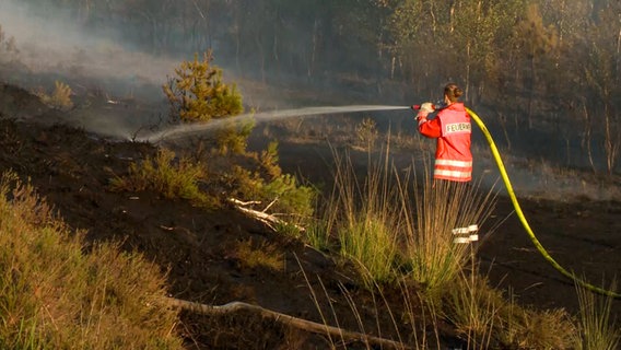 Ein Feuerwehrmann bei Löscharbeiten in einem Moorgebiet. © NonstopNews 