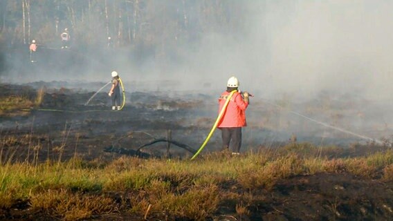 Feuerwehrmänner bei Löscharbeiten in einem Moorgebiet. © NonstopNews 