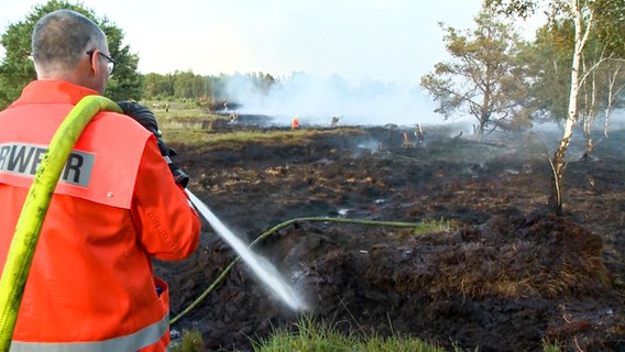 Ein Feuerwehrmann bei Löscharbeiten in einem Moorgebiet. © NonstopNews 