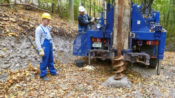 Zwei Männer arbeiten an einer Bohrung im Wald. © NDR.de Foto: Peter Jagla