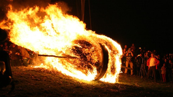 Ein brennendes Osterrad rollt einen Hang hinunter. © Pressestelle Lügde 