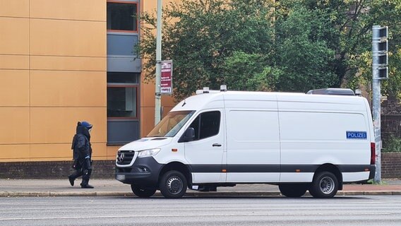 Eine Spezialeinheit der Polizei geht an einem weißen Lieferwagen vorbei. © NDR Foto: Wieland Gabke