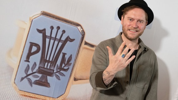 Der Musiker Johannes Oerding posiert mit dem Paul-Lincke-Ring für ein Foto. © picture alliance/dpa | Swen Pförtner Foto: Swen Pförtner