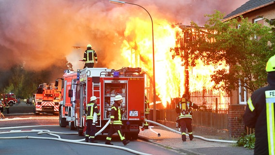 Ein großer Brand: Lagerhallen stehen in Flammen. Davor die Feuerwehr. © Julian Stratenschulte/dpa Foto: Julian Stratenschulte