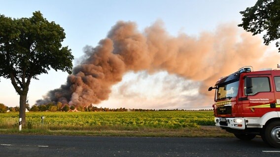 Starke Rauchentwicklung durch einen Brand. Im Vordergrund: ein Feuerwehrwagen. © Julian Stratenschulte/dpa Foto: Julian Stratenschulte