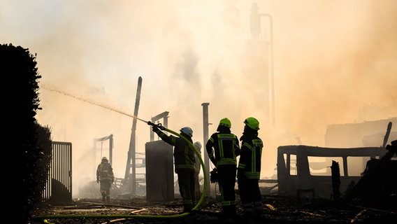 Feuerwehrmänner im Löscheinsatz vor weißem Rauch. © picture alliance/dpa | Julian Stratenschulte Foto: Julian Stratenschulte