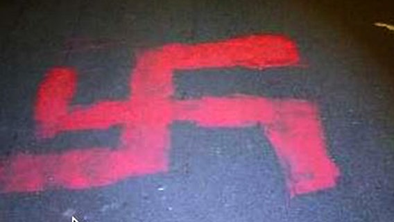 Auf einer Fahrbahn ist mit roter Farbe ein Hakenkreuz gesprüht worden. © Polizei Braunschweig 