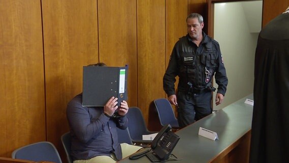 Ein Angeklagter und ein Mitarbeiter der Justiz beim Prozess um das Drogenlabor in Weißenborn. © NDR 