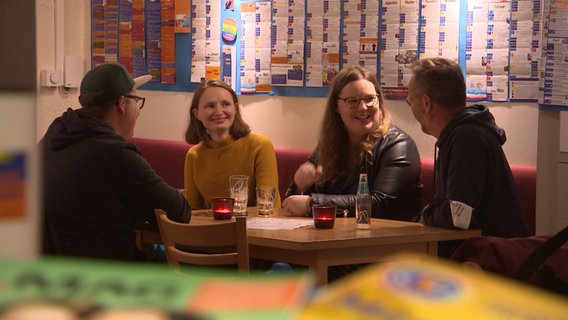 Mehrere Personen sitzen an einem Tisch. © NDR 
