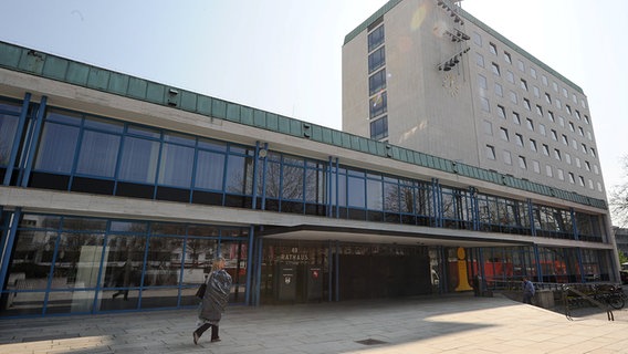 Mehrere Menschen betreten in Wolfsburg das Rathaus. © dpa - Bildfunk Foto: Jochen Lübke