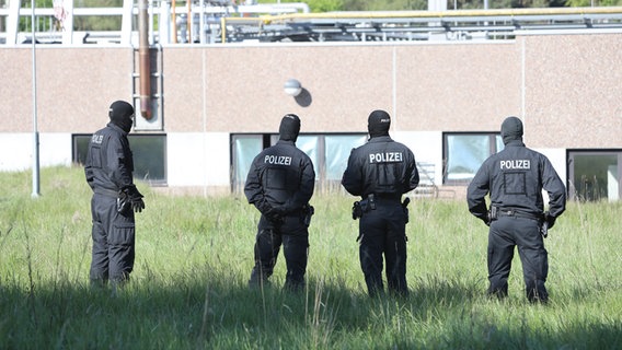 Polizeibeamte stehen während einer Razzia vor einem Gebäude in Liebenburg. © picture alliance/dpa Foto: Frank Neuendorf