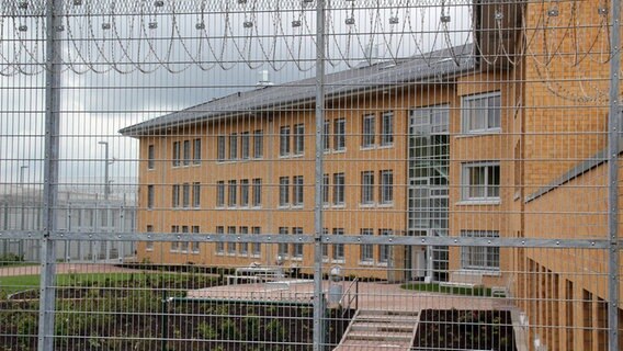 Blick durch einen Gitterzaun auf das neue Gebäude der JVA Rosdorf. © picture alliance Foto: Stefan Rampfel