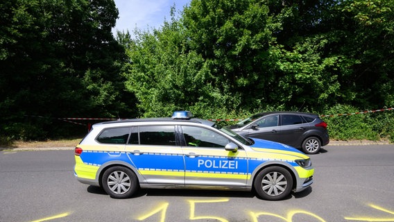 Ein Fahrzeug der Polizei fährt an einem Tatort an einer Grünfläche am Hans-Böckler-Ring in Salzgitter vorbei © Julian Stratenschulte/dpa Foto: Julian Stratenschulte