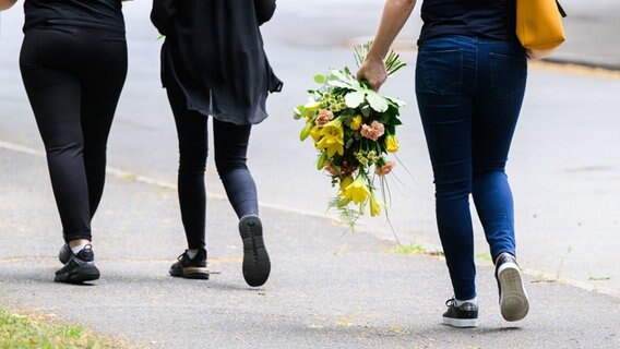 Ein Polizist steht auf dem städtischen Friedhof Salzgitter-Lebenstedt, auf dem eine Trauerfeier für die getötete 15-jährige Anastasia stattfindet. © Julian Stratenschulte/dpa Foto: Julian Stratenschulte