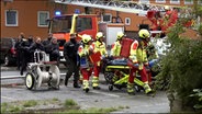 Einsatzkräfte übergeben nach einem Feuer in Salzgitter einen Mann dem Rettungsdienst. © TeleNewsNetwork 