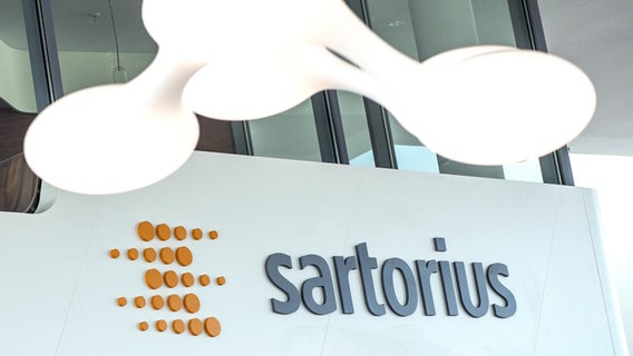 Unter einer Lampe ist das Logo und der Schriftzug des Pharma- und Laborausrüsters Sartorius zu sehen. © picture alliance/Swen Pförtner Foto: Swen Pförtner