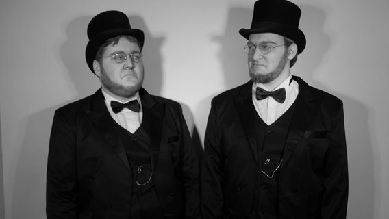 Die Figuren Ebenezer Scrooge (Nils Finck, Gebärdensprache) und Ebenezer Scrooge (Tom Röber, Lautsprache) posieren für ein schwarz-weiß Bild. © Marni Hanke Foto: Marni Hanke